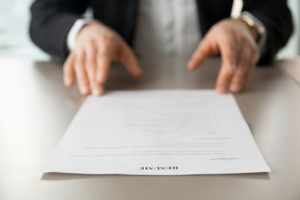 Person looking at their resume at a table.